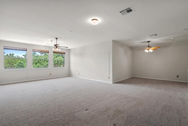 spare room featuring a ceiling fan, carpet floors, and baseboards