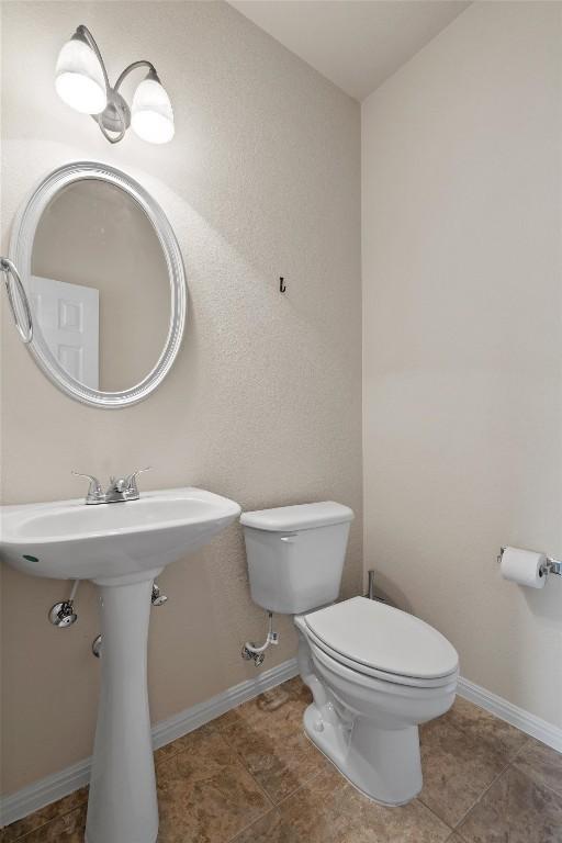 half bath with toilet and baseboards