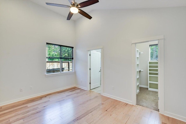 1305 Casey St Unit A, Austin, TX 78745 - unfurnished bedroom featuring wood finished floors, a walk in closet, high vaulted ceiling, and a ceiling fan