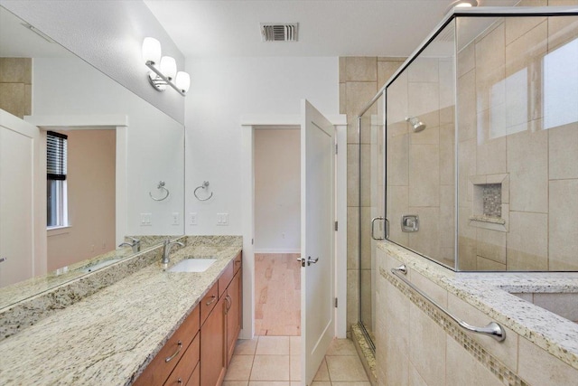 bathroom featuring a stall shower, tile patterned flooring, and vanity