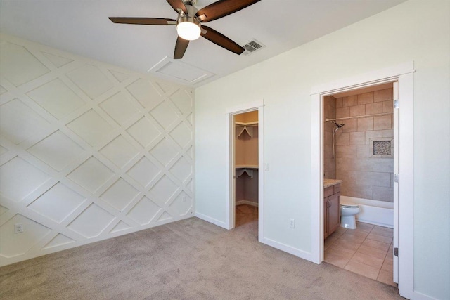 unfurnished bedroom with a spacious closet, light colored carpet, a closet, baseboards, and attic access