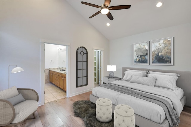 bedroom with high vaulted ceiling, light wood-style floors, recessed lighting, a walk in closet, and ensuite bath