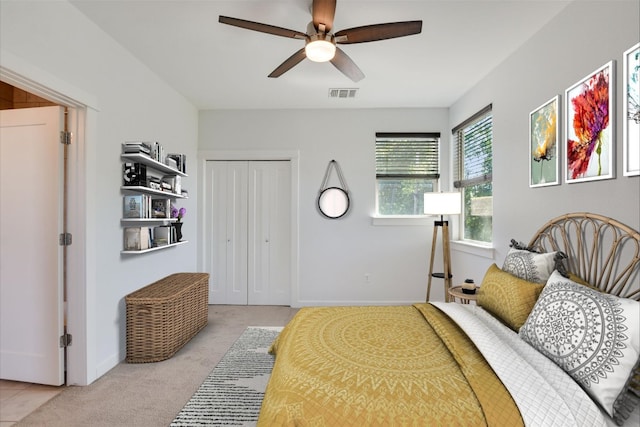 carpeted bedroom featuring a closet, baseboards, and a ceiling fan