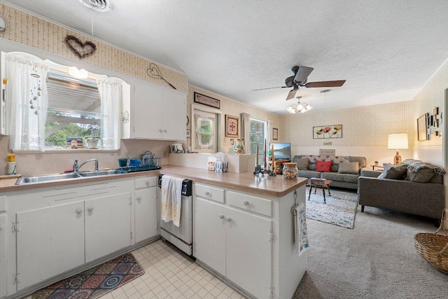 3108 W Terrace Dr, Austin, TX 78757 - kitchen featuring dishwashing machine, a peninsula, wallpapered walls, a ceiling fan, and white cabinets