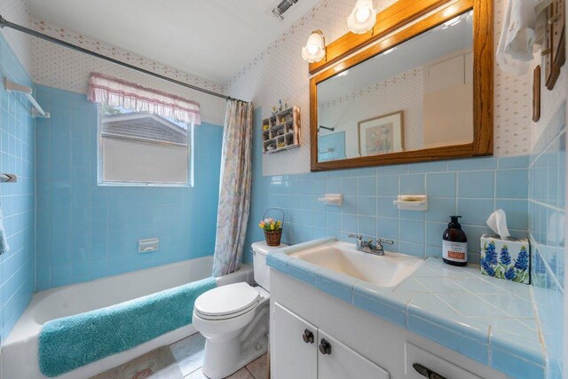 3108 W Terrace Dr, Austin, TX 78757 - bathroom with shower / bath combination with curtain, toilet, vanity, tile walls, and wallpapered walls
