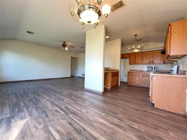 11729 Timber Heights Dr, Austin, TX 78754 - kitchen with stainless steel microwave, a chandelier, lofted ceiling, ceiling fan, and brown cabinetry