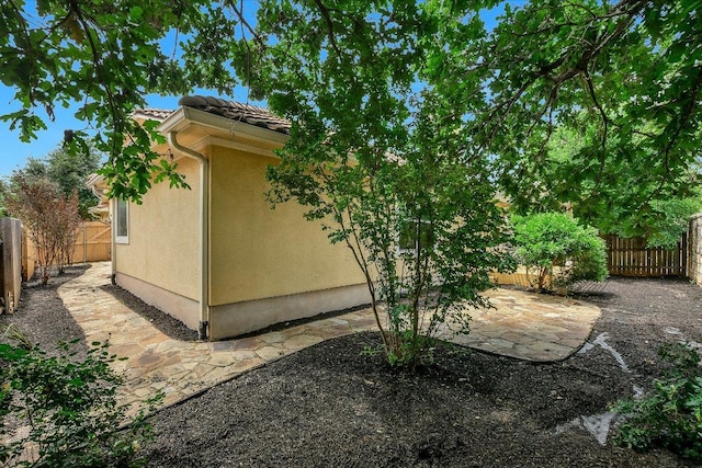 15628 Interlachen Dr, Austin, TX 78717 - view of side of property featuring a patio, a fenced backyard, stucco siding, and a tiled roof