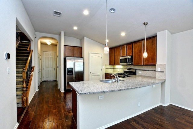 15628 Interlachen Dr, Austin, TX 78717 - kitchen with appliances with stainless steel finishes, a peninsula, dark wood-style floors, decorative backsplash, and lofted ceiling
