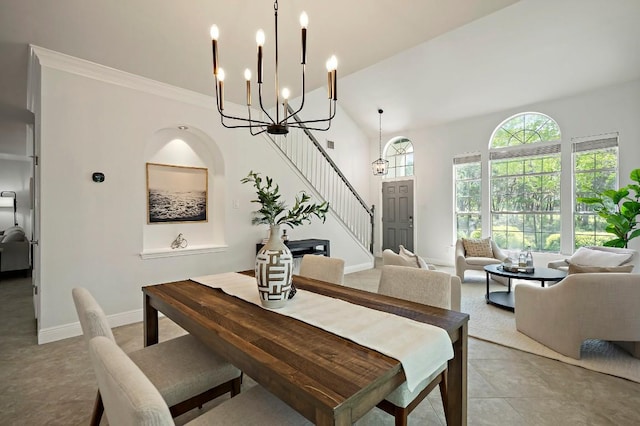 dining area featuring a chandelier, stairs, and baseboards