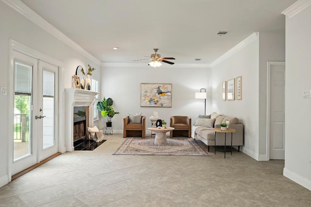 living area featuring ceiling fan, a high end fireplace, ornamental molding, baseboards, and light tile patterned flooring