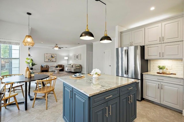 kitchen with freestanding refrigerator, a kitchen island, backsplash, pendant lighting, and recessed lighting