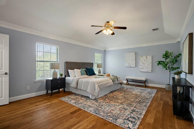 bedroom featuring ornamental molding, wood finished floors, baseboards, and a ceiling fan