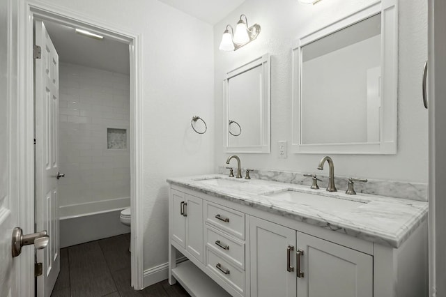 bathroom with double vanity and toilet