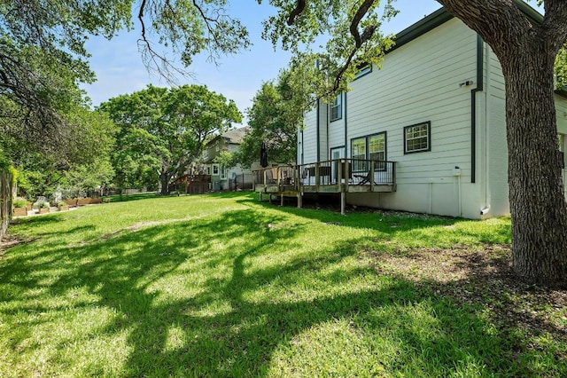 view of green lawn featuring a wooden deck