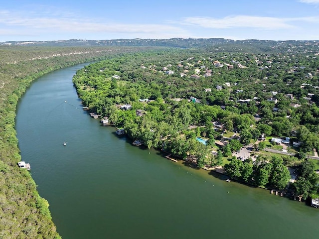 aerial view of property's location featuring a large body of water and a heavily wooded area