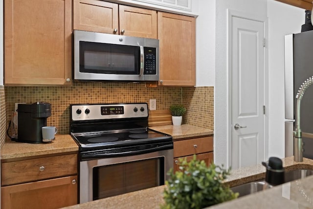 3204 Menchaca Rd Unit 716, Austin, TX 78704 - kitchen featuring appliances with stainless steel finishes, decorative backsplash, and light stone counters