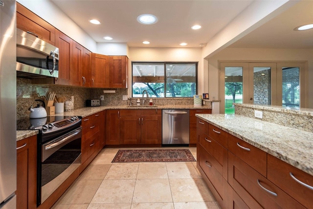 kitchen featuring appliances with stainless steel finishes, a sink, plenty of natural light, decorative backsplash, and recessed lighting