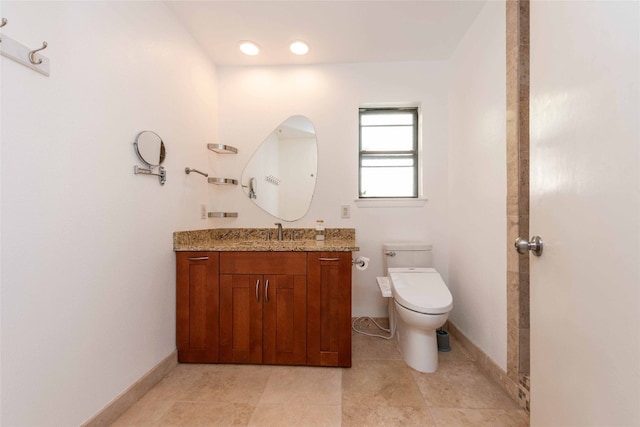bathroom with toilet, vanity, baseboards, and tile patterned floors