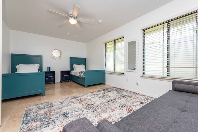 tiled bedroom featuring baseboards and a ceiling fan