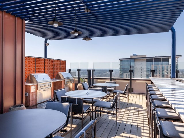 wooden terrace featuring outdoor dining area, area for grilling, and a water view