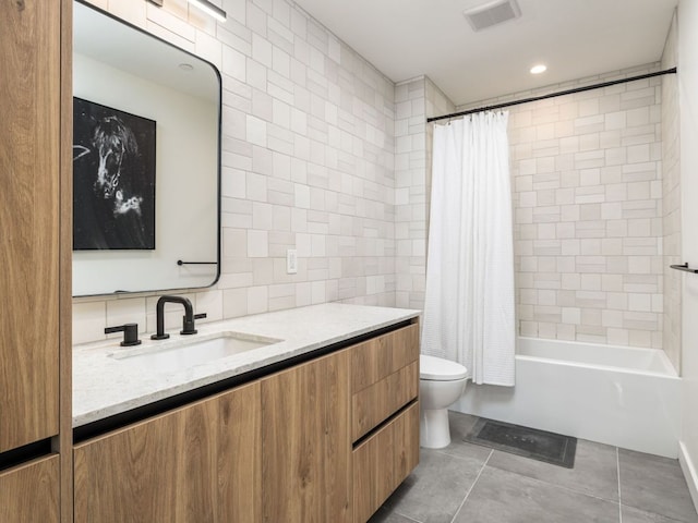 bathroom featuring tile walls, toilet, vanity, tile patterned floors, and shower / bath combo