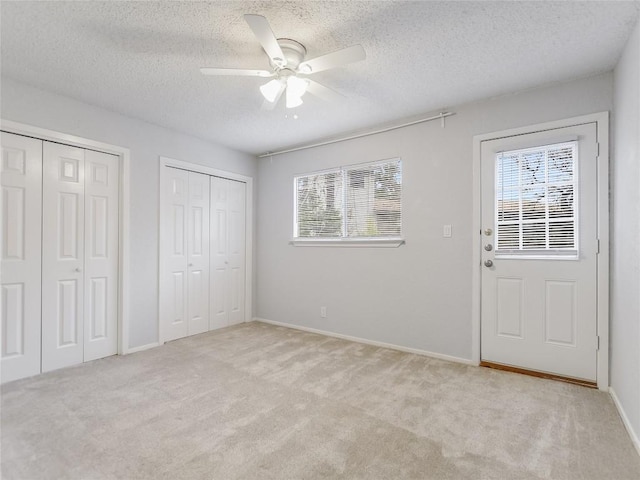 1912 Lightsey Rd Unit 1, Austin, TX 78704 - unfurnished bedroom with multiple closets, light colored carpet, a textured ceiling, baseboards, and ceiling fan