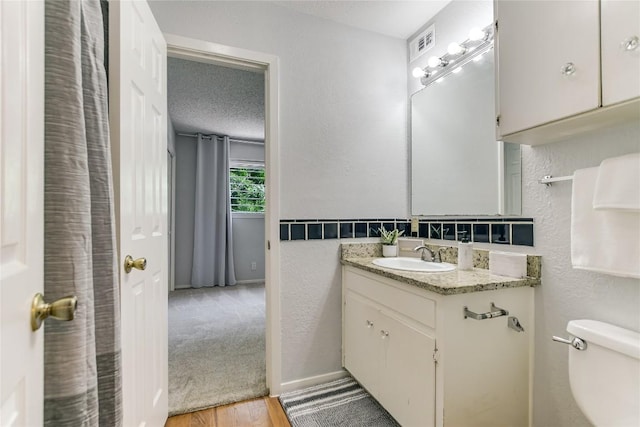 1912 Lightsey Rd Unit 1, Austin, TX 78704 - bathroom featuring wood finished floors, toilet, vanity, a textured wall, and a textured ceiling