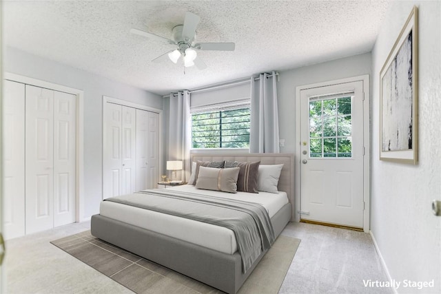 1912 Lightsey Rd Unit 1, Austin, TX 78704 - carpeted bedroom featuring a textured ceiling, two closets, a ceiling fan, and baseboards
