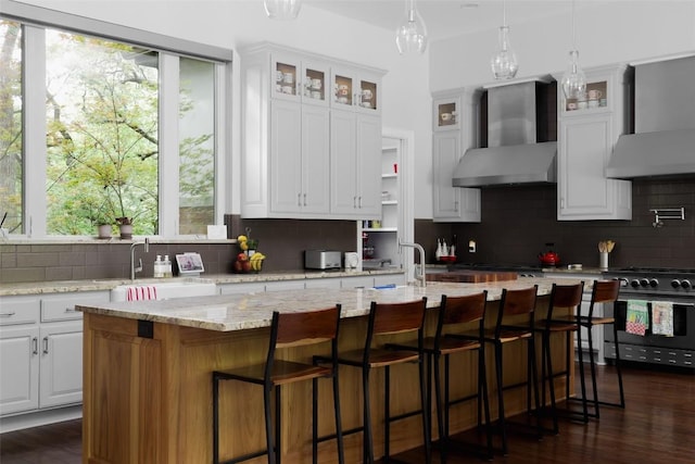 401 Rocky River Rd, West Lake Hills, TX 78746 - kitchen with wall chimney exhaust hood, gas range, backsplash, and white cabinetry