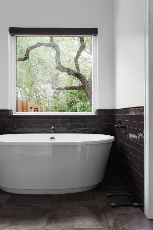 401 Rocky River Rd, West Lake Hills, TX 78746 - full bath featuring tile walls, a soaking tub, and wainscoting