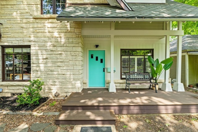 entrance to property with stone siding and a porch
