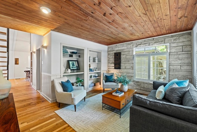living area with wooden ceiling, built in shelves, and wood finished floors