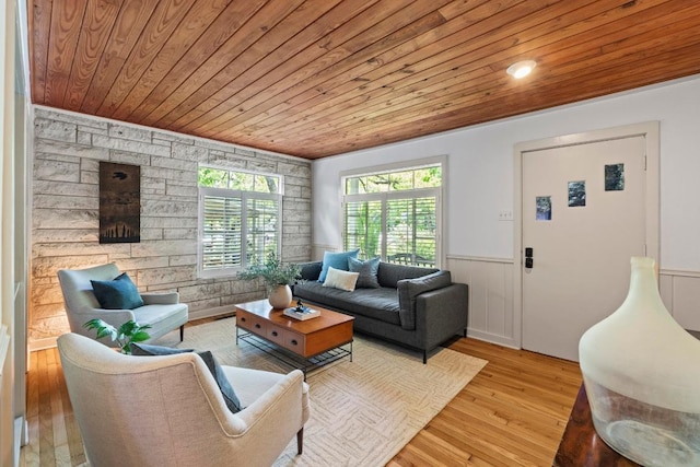 living area with wood ceiling, wainscoting, and wood finished floors