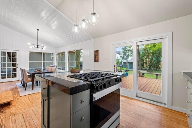 kitchen with gas stove, lofted ceiling, light wood finished floors, a chandelier, and healthy amount of natural light