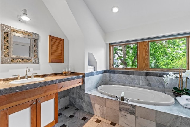 full bath with a bath, lofted ceiling, and vanity