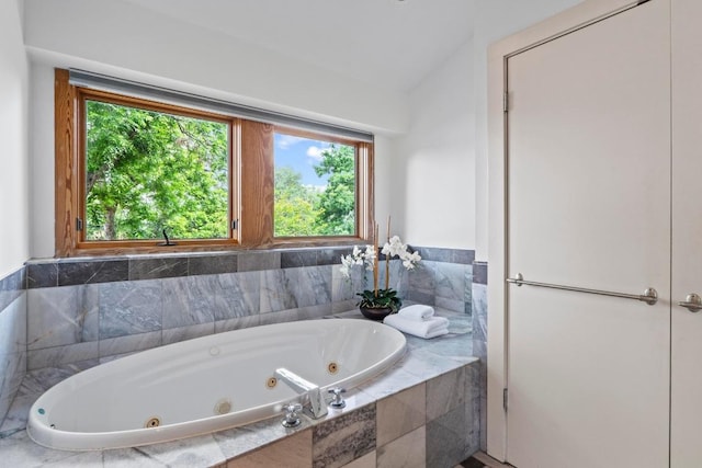 full bath featuring plenty of natural light and a tub with jets