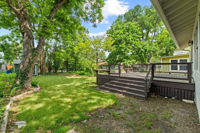 view of green lawn with a deck