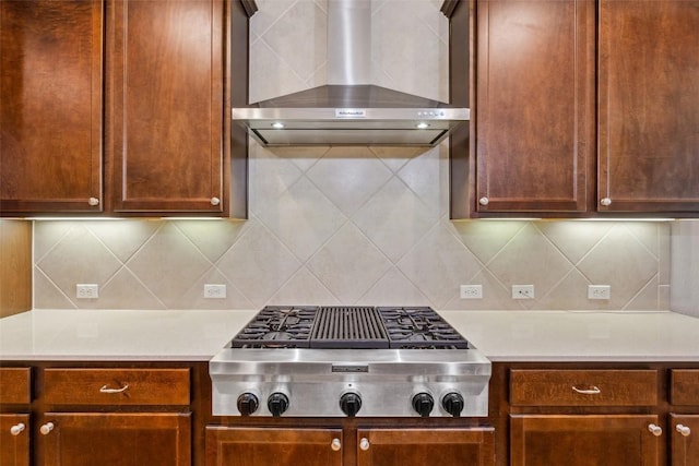 419 Davis Mountain Cir, Georgetown, TX 78633 - kitchen featuring stainless steel gas stovetop, wall chimney range hood, light countertops, and tasteful backsplash