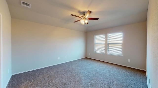 spare room with ceiling fan, dark carpet, and baseboards
