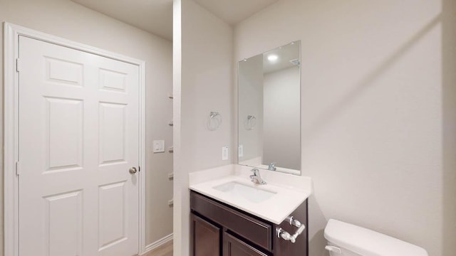 half bath featuring toilet and vanity