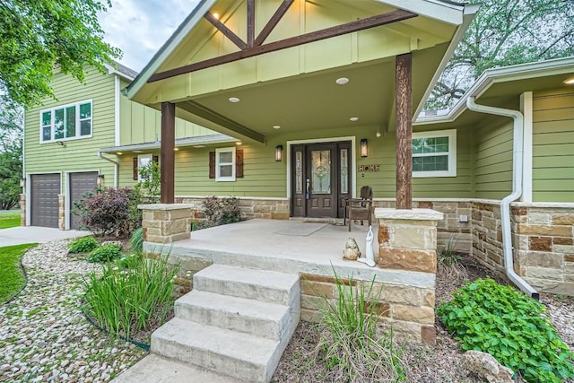 100 Comanche Trl, Georgetown, TX 78633 - view of exterior entry with covered porch, a garage, stone siding, and driveway