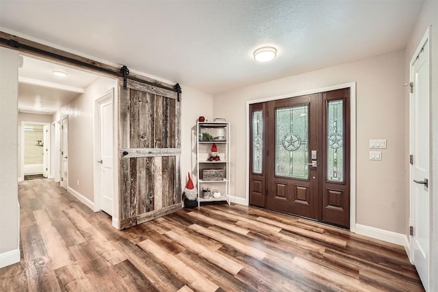 100 Comanche Trl, Georgetown, TX 78633 - entryway featuring a barn door, wood finished floors, and baseboards