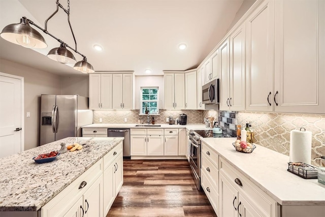100 Comanche Trl, Georgetown, TX 78633 - kitchen with stainless steel appliances, dark wood finished floors, a sink, decorative backsplash, and a kitchen island