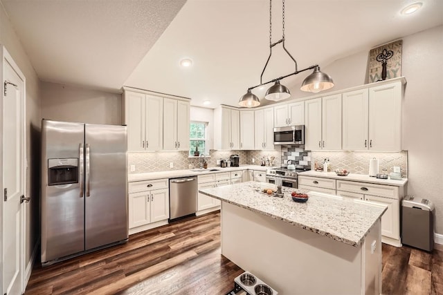 100 Comanche Trl, Georgetown, TX 78633 - kitchen featuring appliances with stainless steel finishes, backsplash, white cabinetry, dark wood-type flooring, and a kitchen island