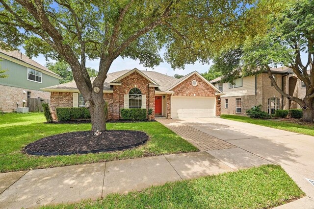 2713 Oakwood Glen Dr, Cedar Park, TX 78613 - traditional home featuring a garage, driveway, a front yard, brick siding, and roof with shingles