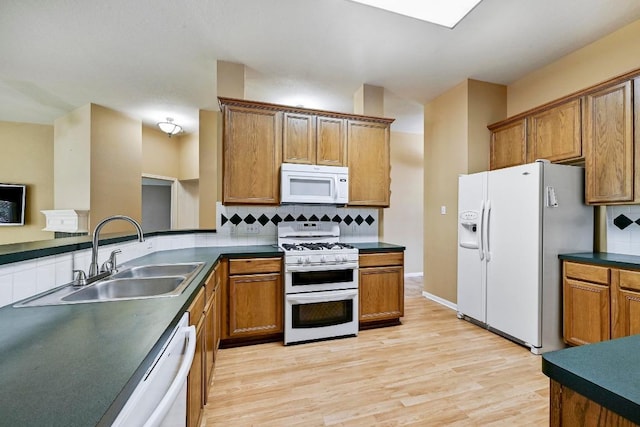 2713 Oakwood Glen Dr, Cedar Park, TX 78613 - kitchen featuring white appliances, dark countertops, and brown cabinets