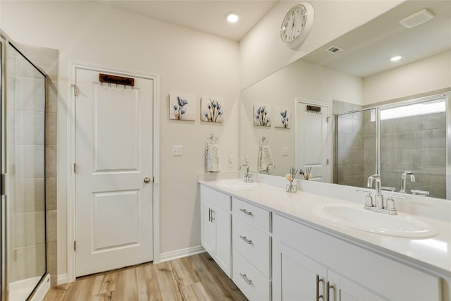 104 Hannah Trl, Georgetown, TX 78628 - bathroom featuring double vanity, a shower stall, wood finished floors, and baseboards