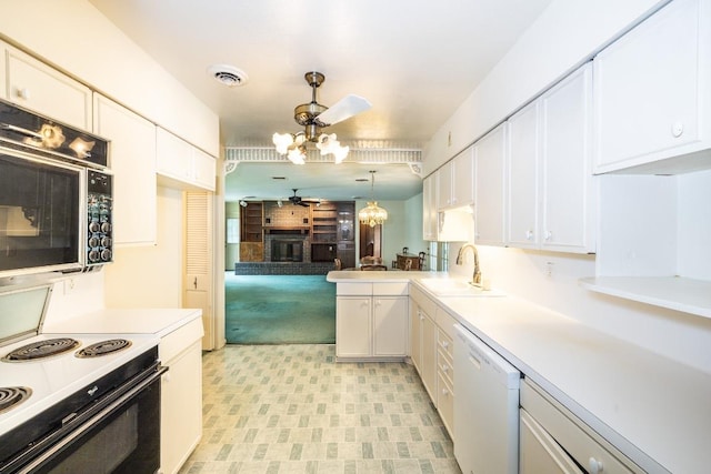 104 N Fair St, Gonzales, TX 78629 - kitchen featuring ceiling fan, white appliances, a sink, a glass covered fireplace, and white cabinetry