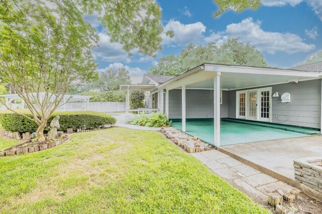 104 N Fair St, Gonzales, TX 78629 - back of property featuring french doors, driveway, and a carport