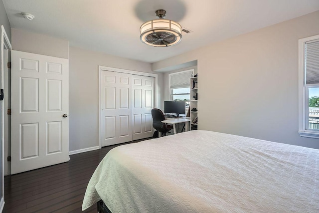 6900 E Riverside Dr Unit 6, Austin, TX 78741 - bedroom featuring dark wood-type flooring, multiple windows, an office area, and a closet